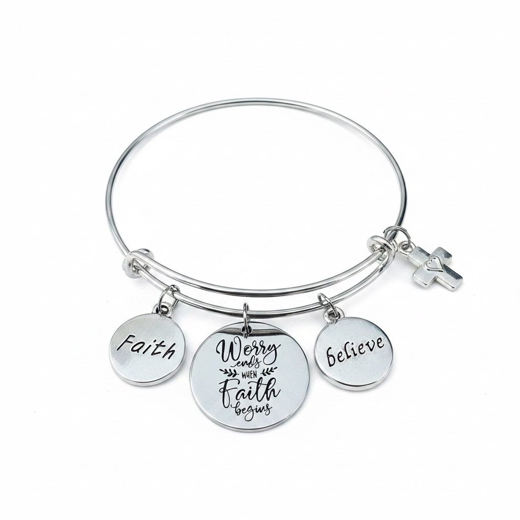 Professional studio photo of silver faith charm bangle bracelet with engraved Faith, Believe, Worry Ends When Faith Begins discs and cross charm on white background — Jules Obsession