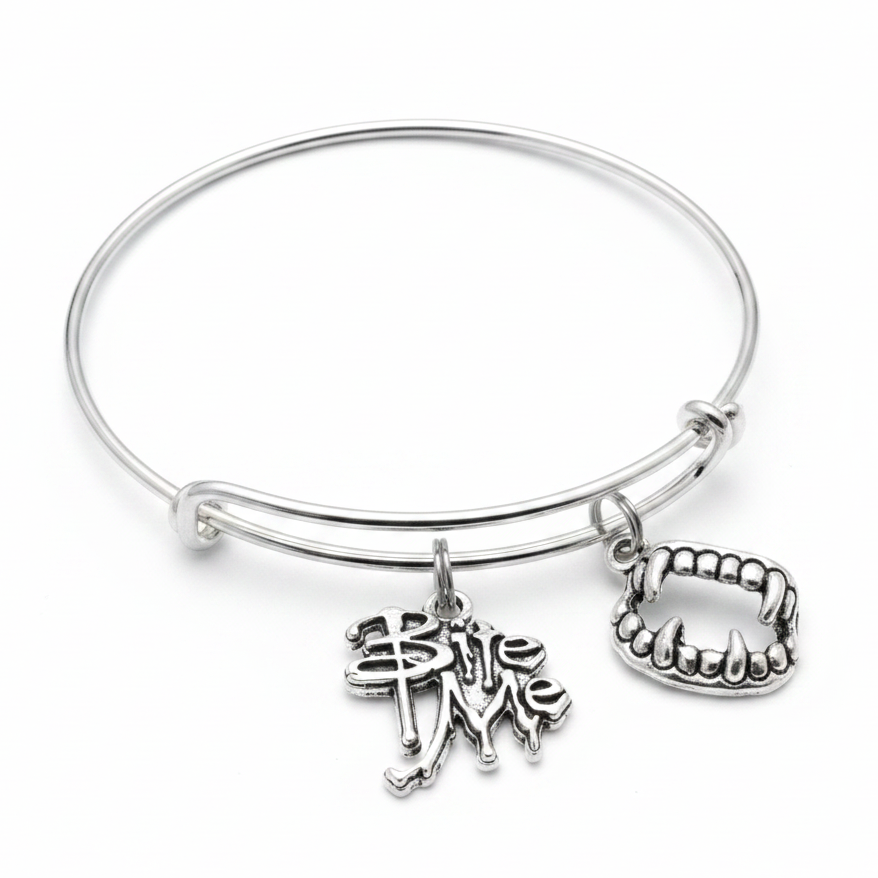 Silver expandable wire bangle bracelet on white background featuring a Bite Me gothic drip text charm and a silver vampire mouth charm with prominent fangs