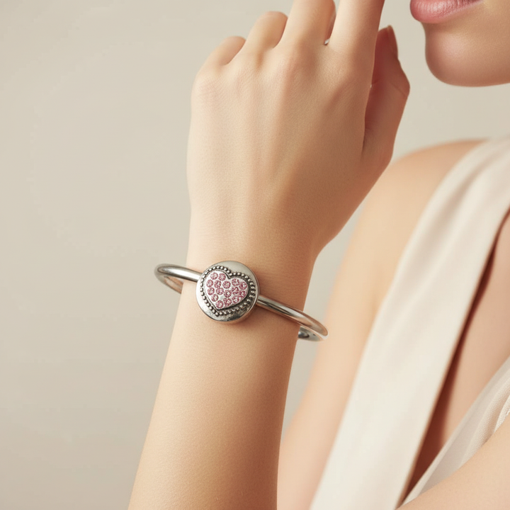 Woman wearing silver cuff bracelet with pink crystal rhinestone heart snap charm – interchangeable 18mm snap bracelet by Jules Obsession