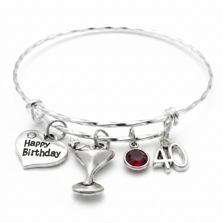 Silver twisted wire expandable 40th birthday charm bracelet with Happy Birthday heart, martini glass, garnet birthstone crystal, and number 40 charms on white background - Jules Obsession
