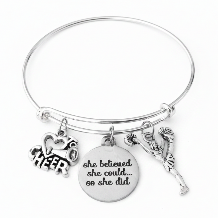 Silver expandable charm bangle bracelet with CHEER megaphone charm, she believed she could so she did engraved disc charm, and cheerleader figure charm, handcrafted by Jules Obsession