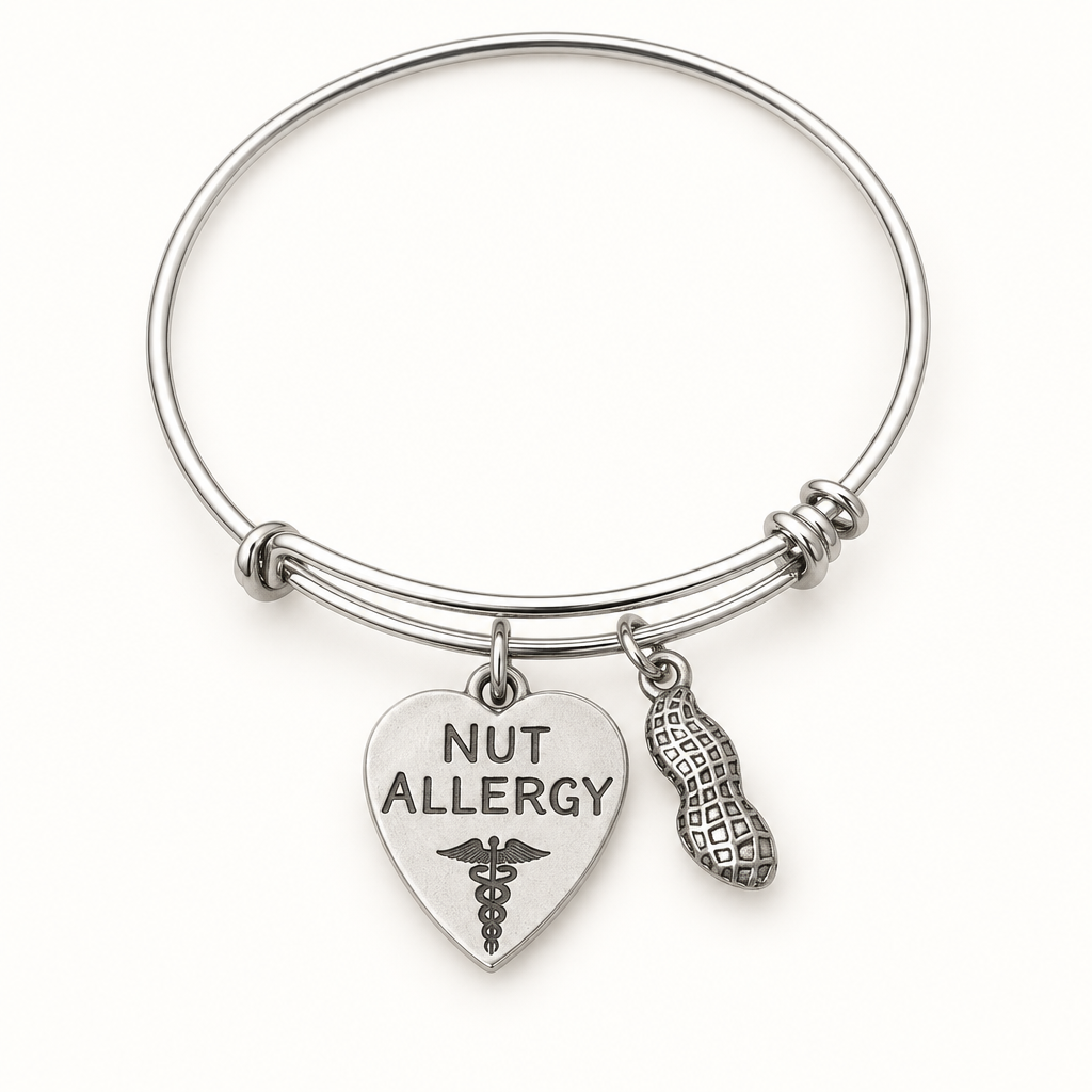 Silver nut allergy medical alert bangle with heart-shaped medical ID charm and peanut charm on a white background