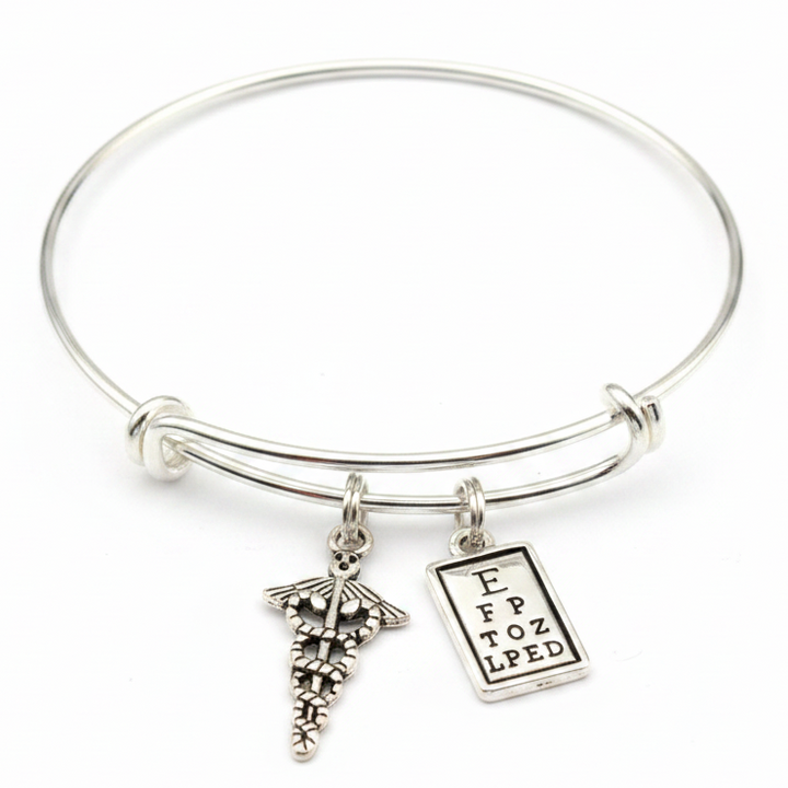 Silver expandable bangle bracelet with caduceus medical symbol charm and eye chart charm on white background – Jules Obsession optometrist eye doctor gift jewelry