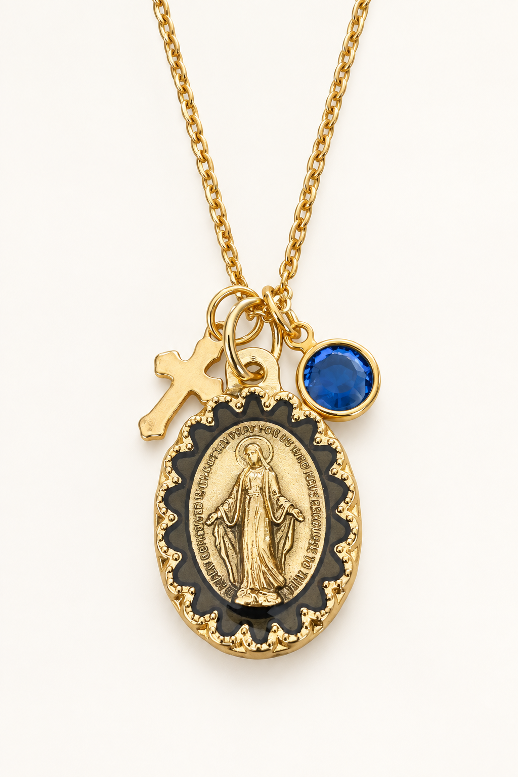 Gold-tone necklace with an oval religious medal, a small gold cross charm, and a round birthstone charm.