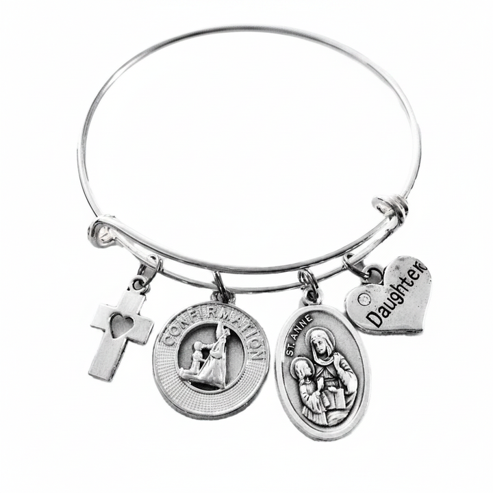 Silver expandable bangle bracelet with cross heart charm, Confirmation medallion, St. Anne saint medal, and Daughter heart charm on white background by Jules Obsession