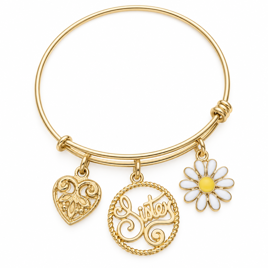 Gold bangle bracelet with a filigree heart charm, a round Sister script charm, and a white and yellow daisy charm, shown on a warm-white studio background