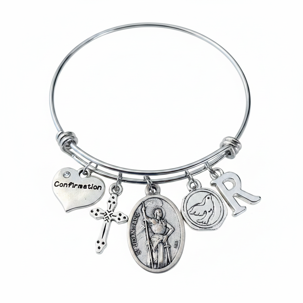 Saint Joan of Arc Confirmation charm bangle bracelet featuring St. Joan of Arc saint medal, cross charm, Confirmation heart, dove charm, and personalized initial charm in silver on white background