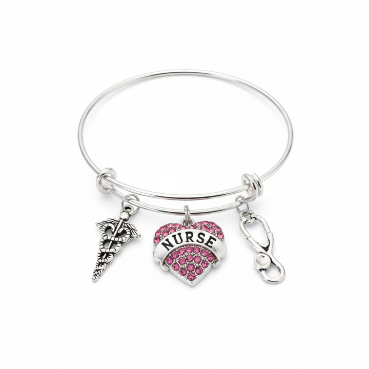 Silver expandable bangle bracelet with pink crystal nurse heart charm, stethoscope charm, and caduceus medical symbol charm on white background