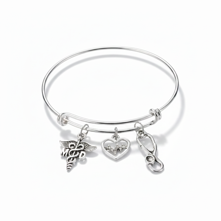 Silver expandable bangle bracelet with MD caduceus charm, crystal EKG heart charm, and stethoscope charm on white background — physician gift jewelry