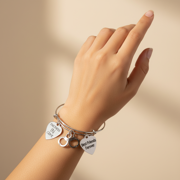 Woman wearing Partners in Crime Best Friends Forever silver charm bangle bracelet with handcuff charm – BFF friendship jewelry by Jules Obsession