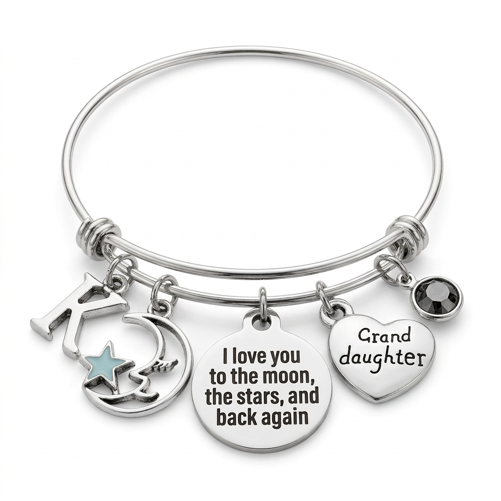 Silver-tone granddaughter bangle with K initial, moon and blue star, engraved message disc, heart and dark crystal on white.