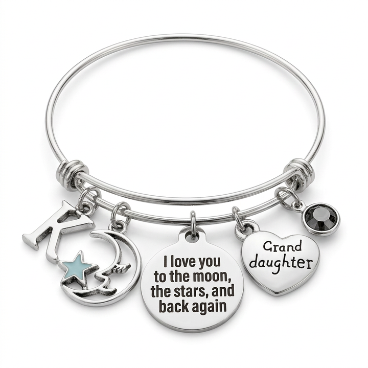 Silver-tone granddaughter bangle with K initial, moon and blue star, engraved message disc, heart and dark crystal on white.