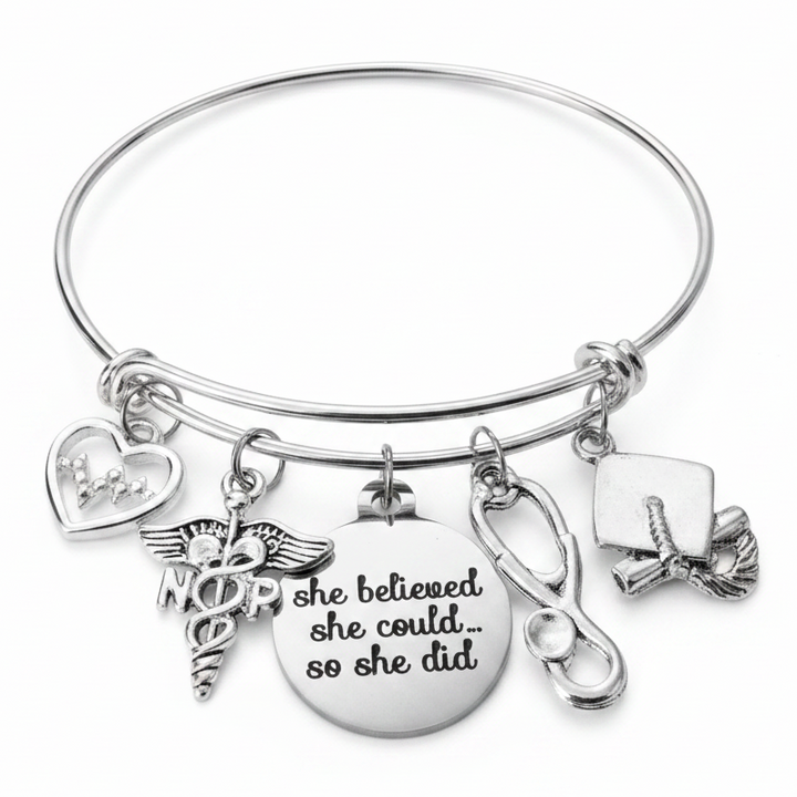 Silver expandable bangle bracelet with NP caduceus nurse practitioner charm, EKG heartbeat heart charm, she believed she could so she did engraved disc, stethoscope charm, and graduation cap charm — nurse practitioner graduation gift bracelet by Jules Obsession