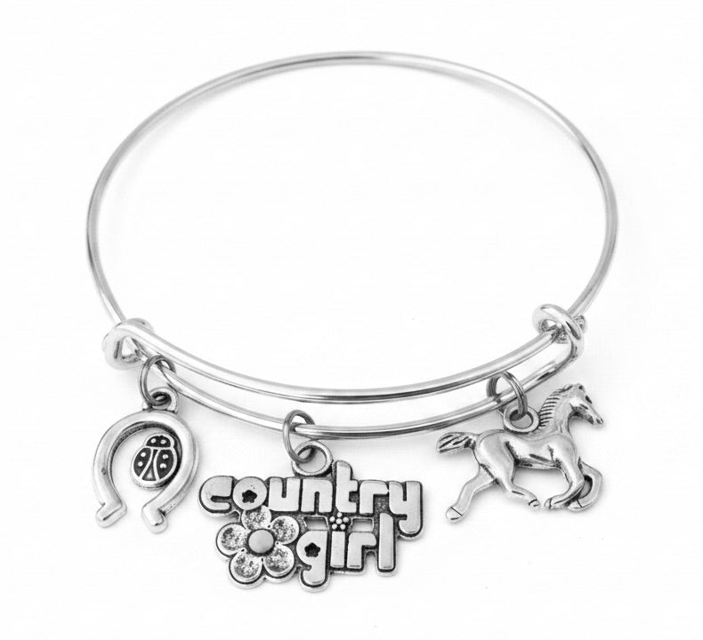 Silver expandable bangle bracelet with Country Girl word charm, horseshoe with ladybug charm, and galloping horse charm on white background – Jules Obsession country girl western gift jewelry