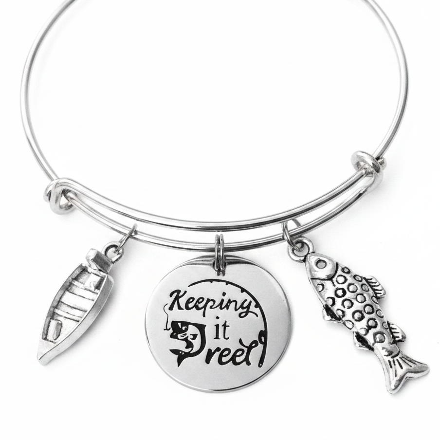 Silver expandable bangle bracelet with Keeping it Reel engraved disc charm, fishing lure charm, and detailed fish charm on white background – Jules Obsession fishing gift jewelry for women
