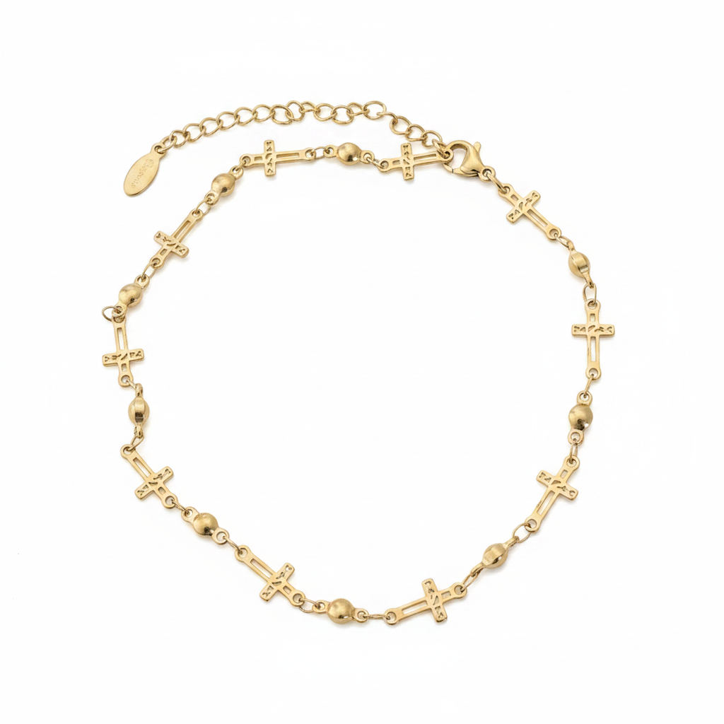 Gold-tone cross charm anklet with heart bead links on white studio background