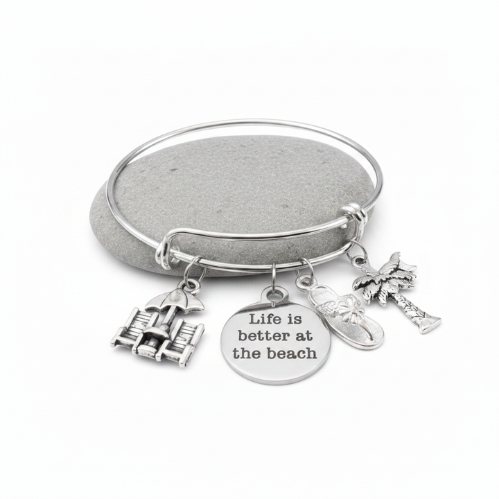 Silver expandable bangle bracelet with four beach-themed charms: beach chairs with umbrella, Life is Better at the Beach engraved disc, flip flop sandal, and palm tree — adjustable stackable gift bracelet for women