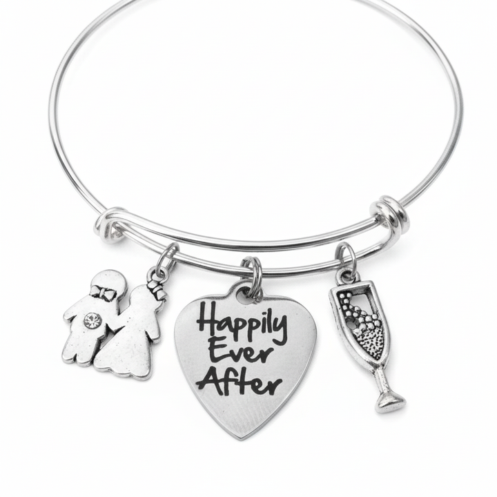 Silver expandable bangle bracelet with Happily Ever After engraved heart charm, bride and groom couple charm with crystal, and champagne flute charm on white background