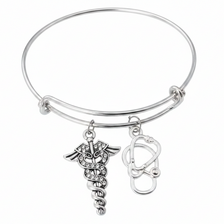 Silver expandable bangle bracelet with crystal caduceus medical symbol charm and stethoscope charm, studio photo on white background