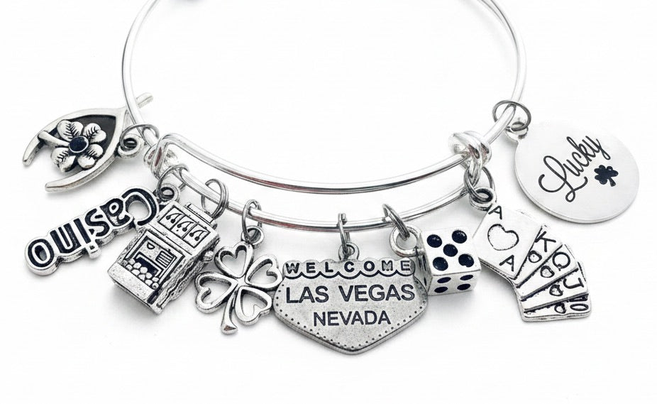 Las Vegas Casino Charm Bracelet with slot machine, dice, playing cards, four leaf clover, Lucky disc, wishbone, Casino text, and Welcome Las Vegas Nevada heart charms — silver expandable bangle gift for gamblers by Jules Obsession