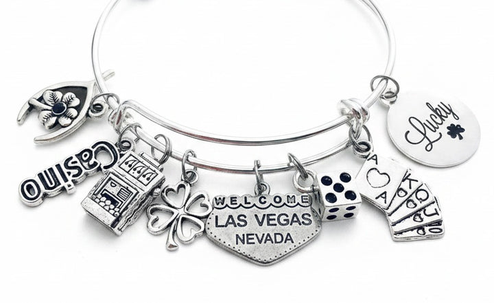 Las Vegas Casino Charm Bracelet with slot machine, dice, playing cards, four leaf clover, Lucky disc, wishbone, Casino text, and Welcome Las Vegas Nevada heart charms — silver expandable bangle gift for gamblers by Jules Obsession