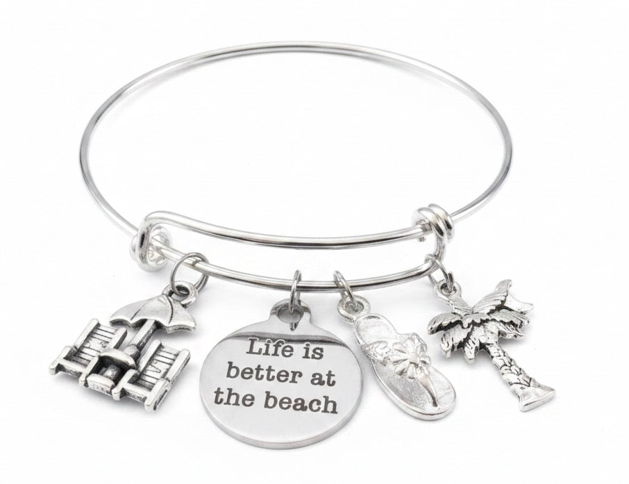 Silver expandable bangle bracelet with four beach-themed charms: beach chairs with umbrella, Life is Better at the Beach engraved disc, flip flop sandal, and palm tree — adjustable stackable gift bracelet for women