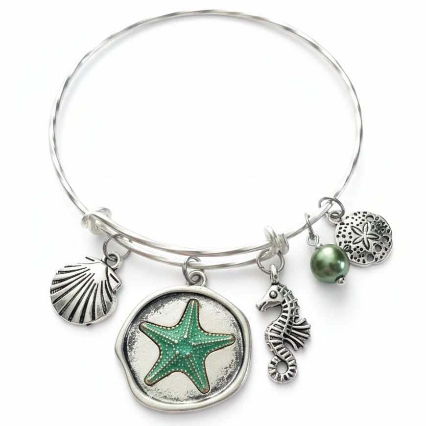 Silver bracelet with starfish, seashell, and seahorse charms on a white background