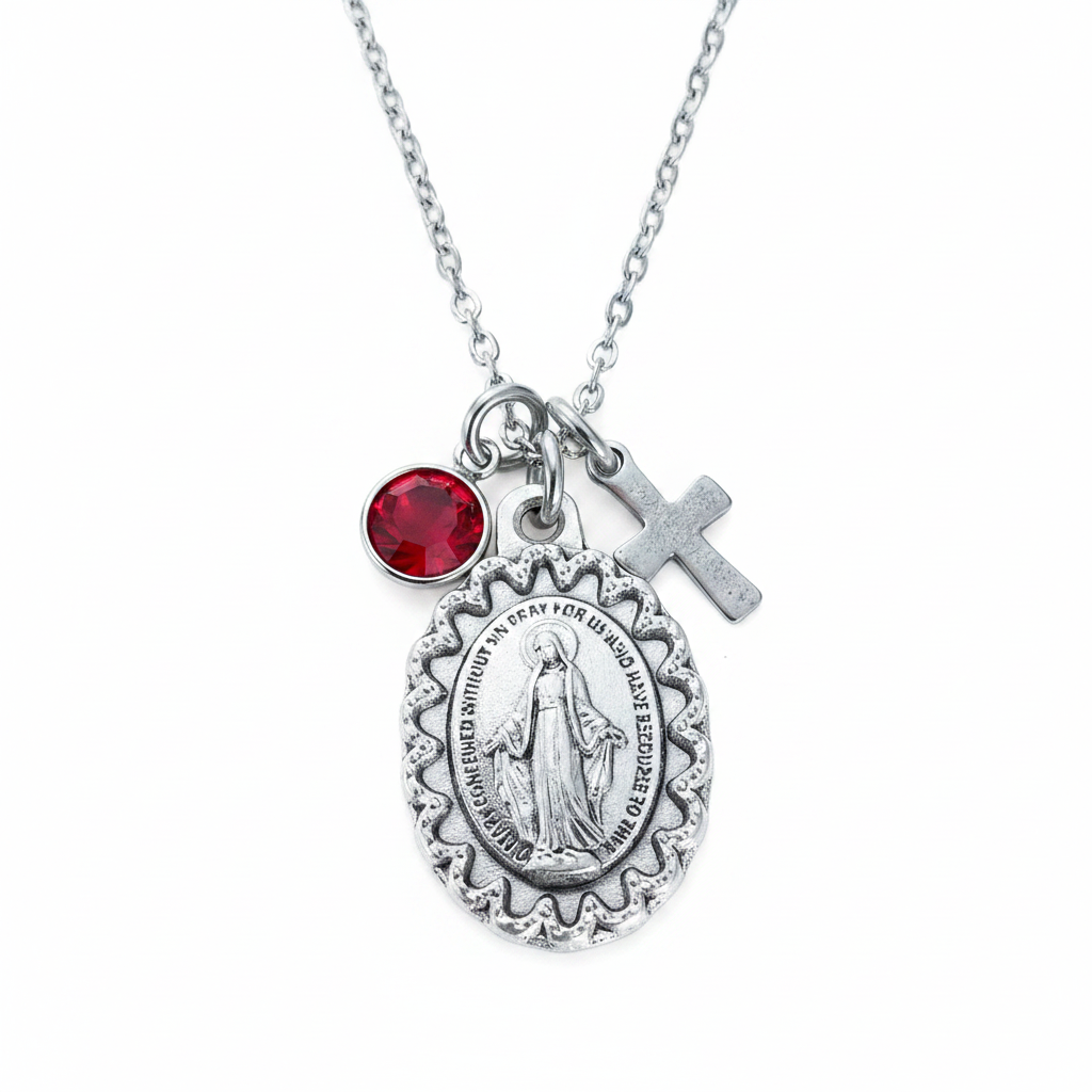 Oxidized silver Virgin Mary miraculous medal necklace on wood surface showing large oval scalloped medal, silver cross charm, and crystal birthstone charm on stainless steel cable chain