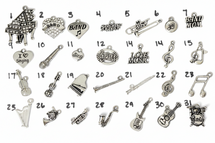 Numbered silver-plated music instrument charm collection for Jules Obsession expandable bangle bracelets including crystal grand piano, crystal BAND fan charm, BAND heart with music note, Marching Bands script charm, trombone, round music note disc, BAND MOM tag, I Love Singing heart, microphone, Sing heart, treble clef and music notes oval, Love Music tag, treble clef charm, treble clef with note, violin, detailed violin, grand piano, flute, conductor baton, treble clef swirl, music note charm, harp, Frenc