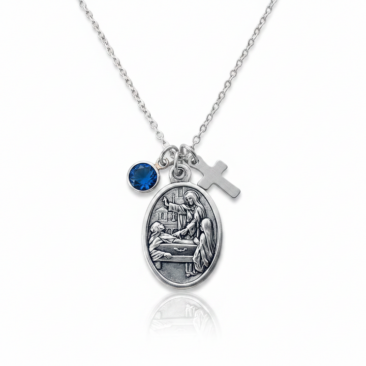 Saint Colette of Corbie silver oxidized medal necklace with faceted blue crystal birthstone charm and stainless steel cross charm on a delicate rope chain — patron saint of fertility, expectant mothers, and sick children