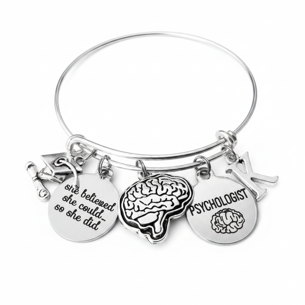 Psychologist graduation gift bracelet on white background — silver bangle with brain charm, she believed she could charm, Psychologist disc, and personalized initial charm