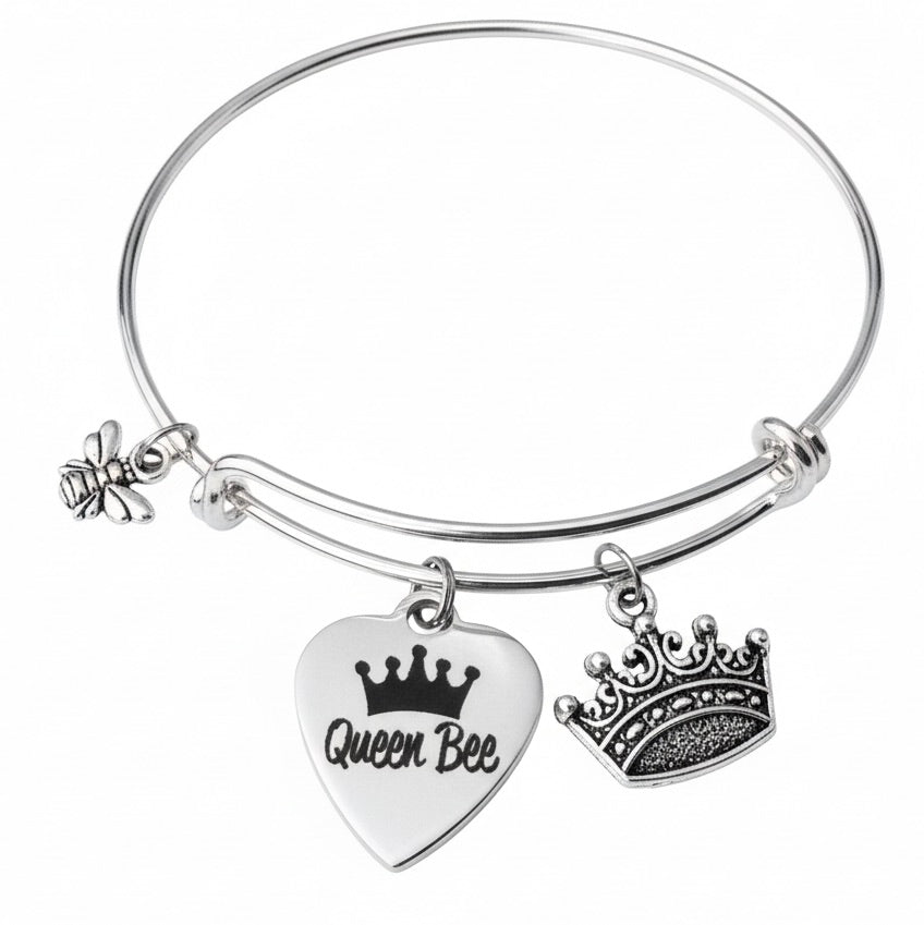 Silver expandable charm bangle bracelet with engraved Queen Bee white enamel heart disc charm, ornate filigree crown charm, and silver bumblebee charm on wire — Queen Bee gift bracelet for her by Jules Obsession