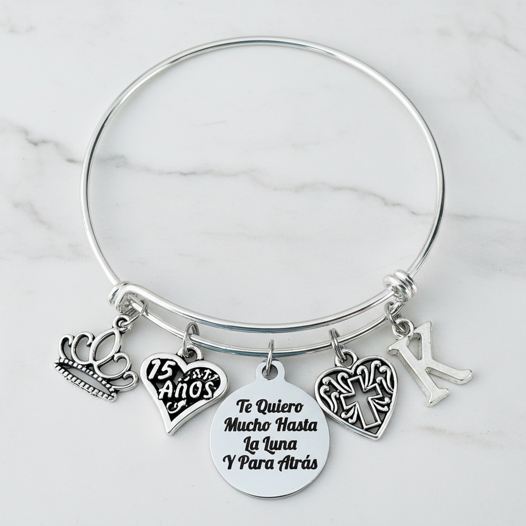 Silver expandable bangle bracelet with crown charm, 15 Años heart charm, Te Quiero Mucho Hasta La Luna engraved disc, filigree cross charm, and personalized initial charm — meaningful Quinceañera gift for girls