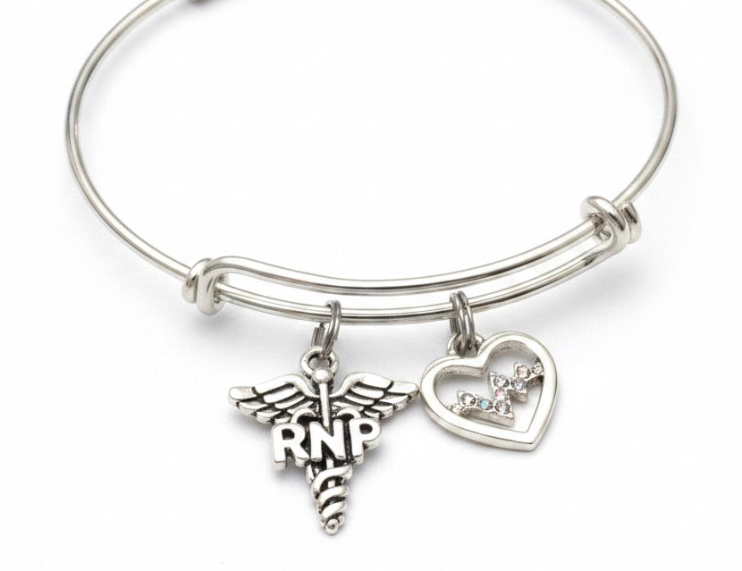A silver-tone expandable wire bangle bracelet featuring a medical caduceus charm with &