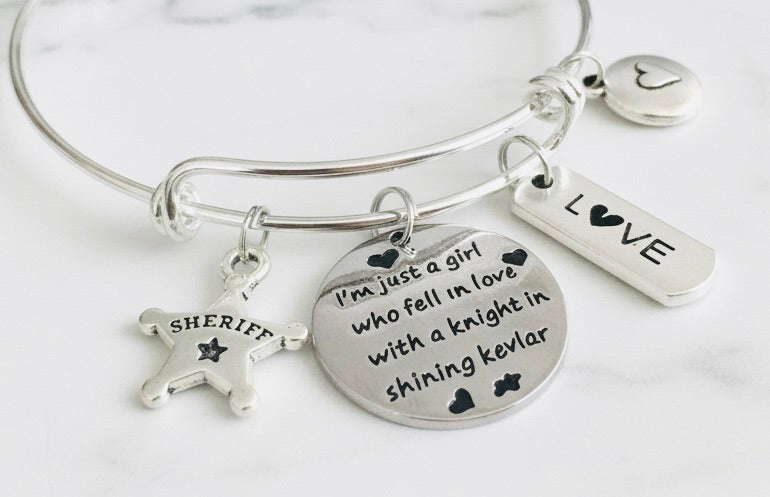 Sheriff wife charm bracelet with expandable wire bangle, silver sheriff star badge, sentiment disc, LOVE bar, and heart coin charm — adjustable law enforcement gift for women