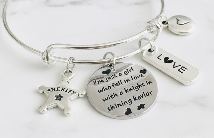 Sheriff wife charm bracelet with expandable wire bangle, silver sheriff star badge, sentiment disc, LOVE bar, and heart coin charm — adjustable law enforcement gift for women