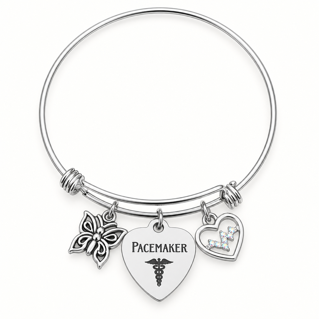 Silver-tone expandable bangle bracelet with a butterfly charm, a heart-shaped “Pacemaker” tag, and an open heart charm with a small butterfly.