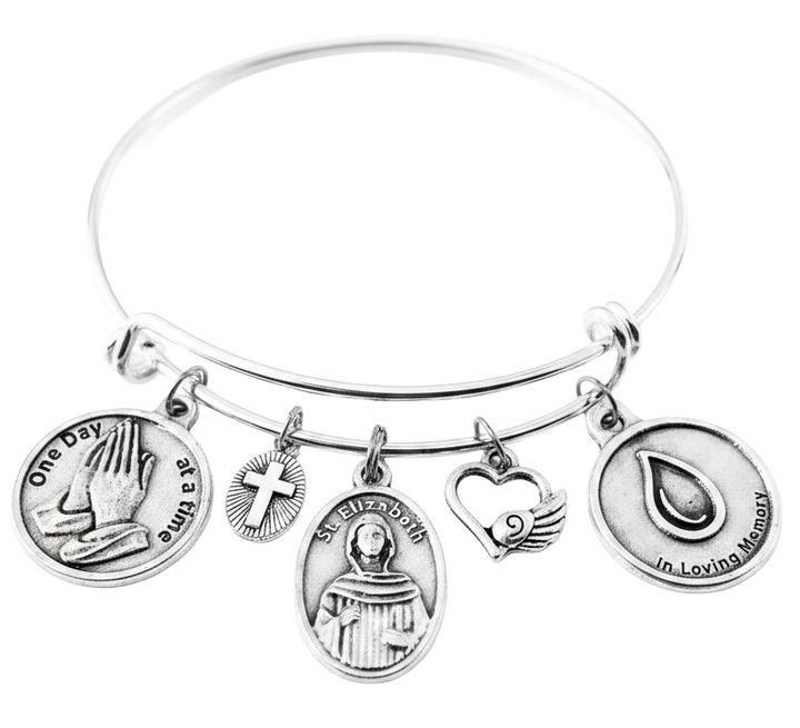Silver expandable charm bangle bracelet featuring One Day at a Time praying hands, cross, Saint Elizabeth Ann Seton medal, angel wing heart, and In Loving Memory teardrop charms 