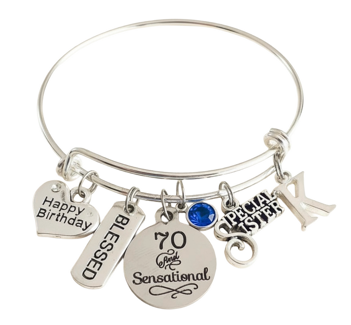 A silver-tone bangle bracelet with multiple engraved charms, including a heart charm reading &