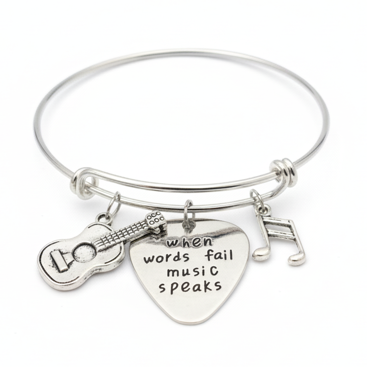 Silver bracelet with guitar and heart charm on a white background