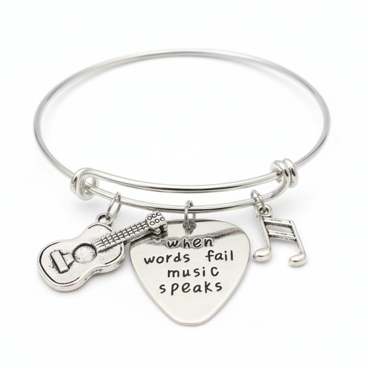 Silver bracelet with guitar and heart charm on a white background