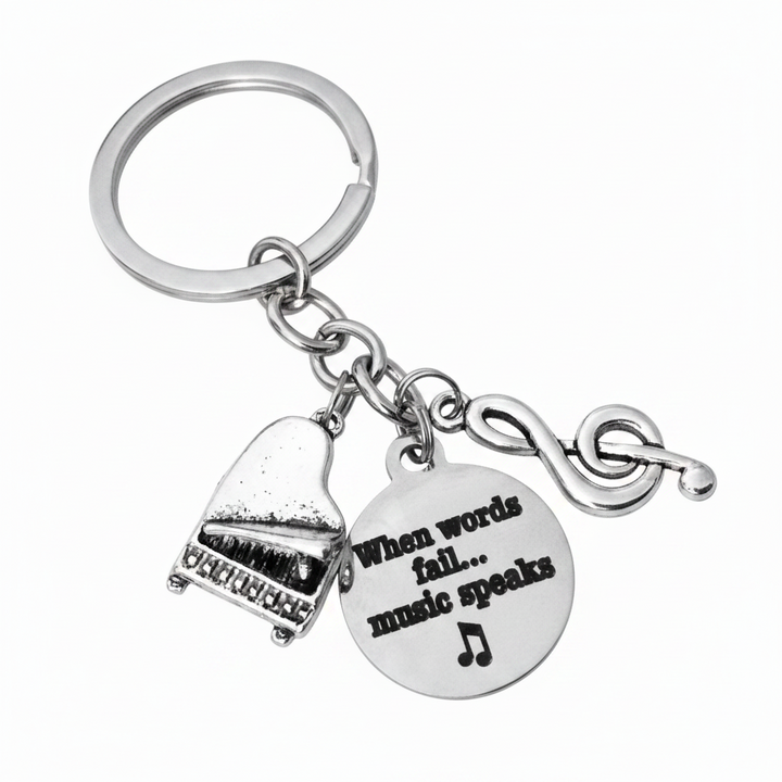 Silver music keychain with baby grand piano charm, treble clef charm, and "When Words Fail Music Speaks" engraved disc — music teacher gift

